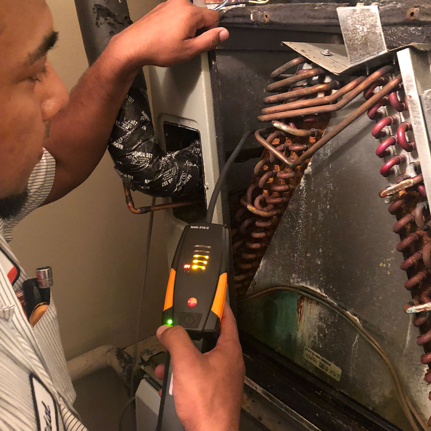 HVAC technician repairing a residential air conditioner in Spring, TX
