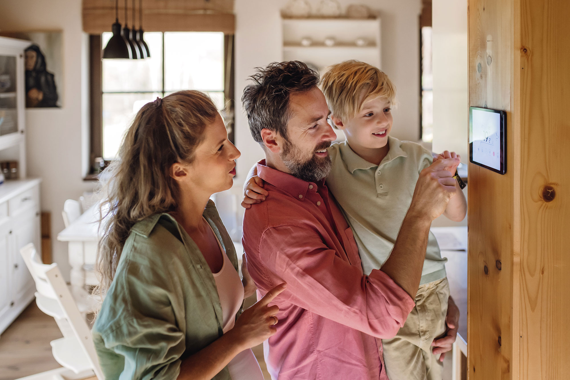 family looking at HVAC thermostat in home